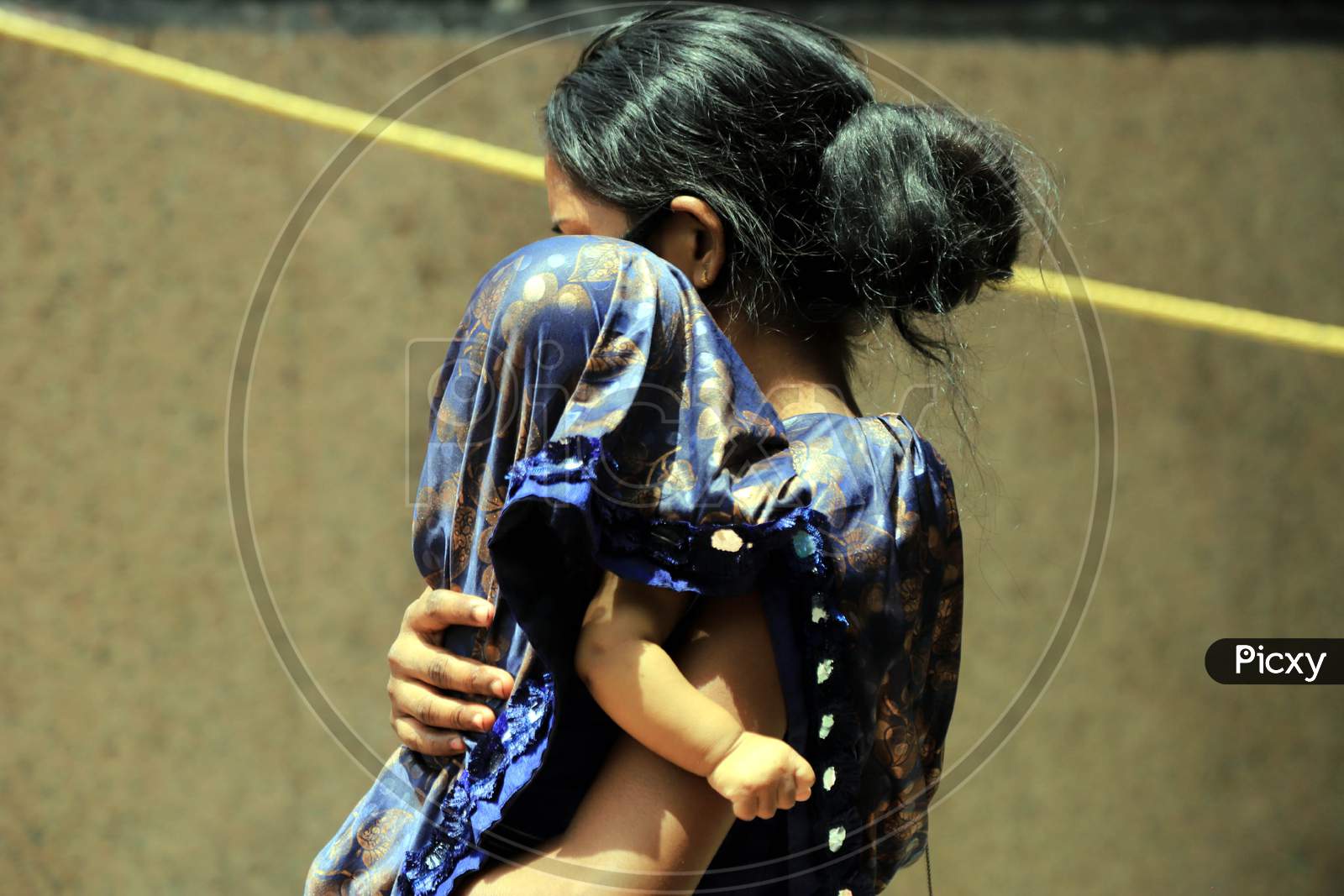 A Woman Covers Her Child On A Hot Day During extended Nationwide Lockdown amidst  Coronavirus or COVID-19 Pandemic  In Prayagraj, May 27, 2020.