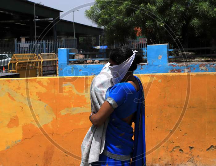 A Woman Covers Her Child To Beat The Heat On A Hot Day During extended Nationwide Lockdown amidst  Coronavirus or COVID-19 Pandemic  In Prayagraj, May 27, 2020.