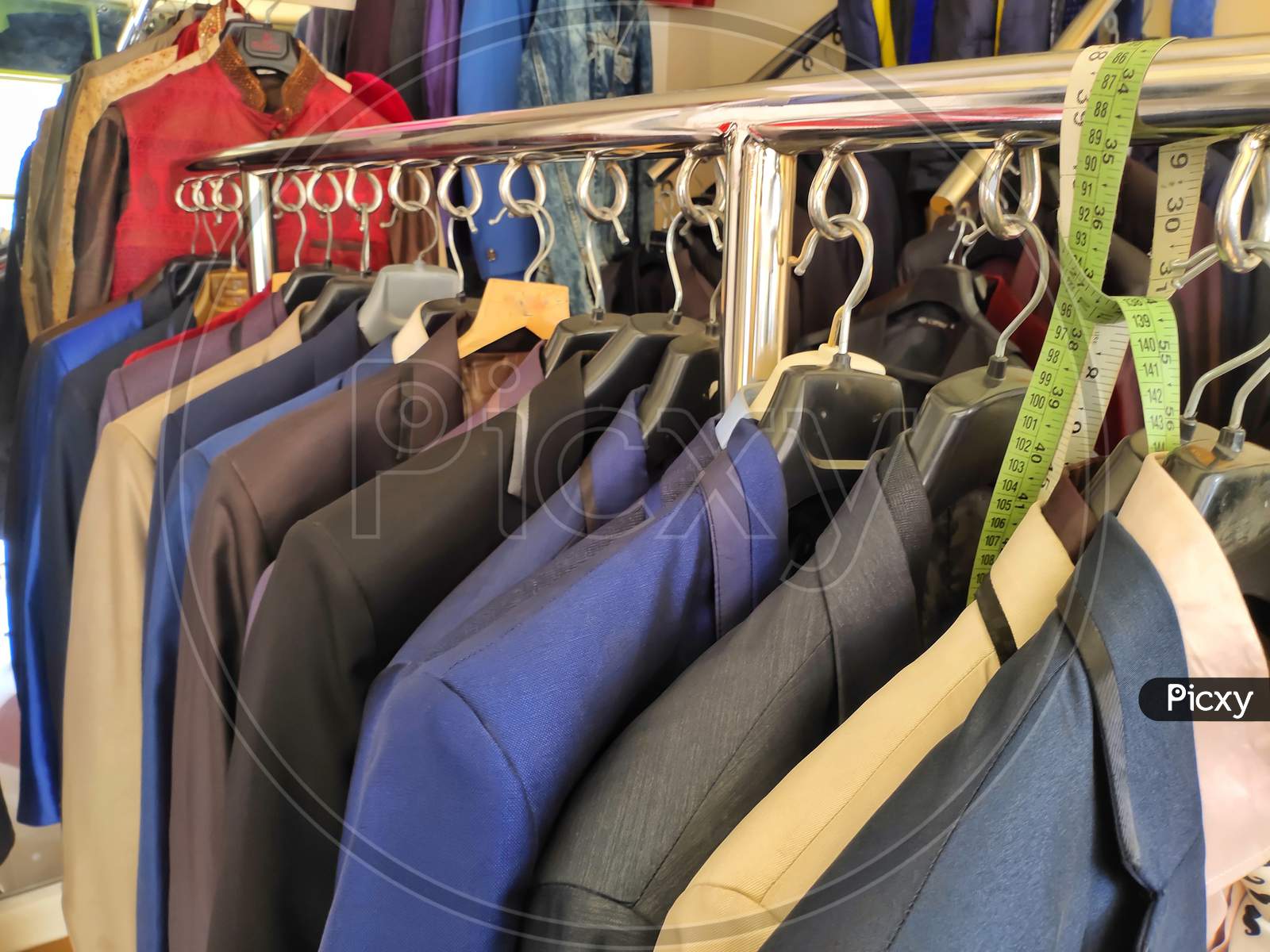 Image of Men multi colored blazers hanging inside a shop .Closeup