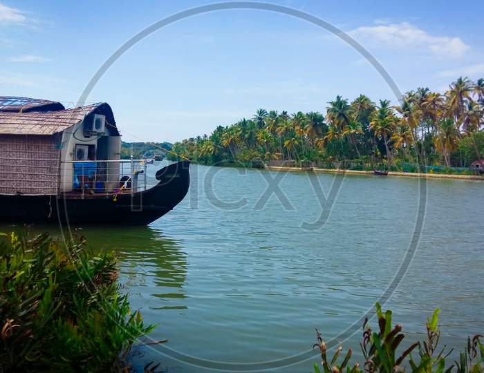 A Houseboat Is Anchored In A Lake At The Kerala Backwaters In India. Houseboat On Kerala Backwaters.