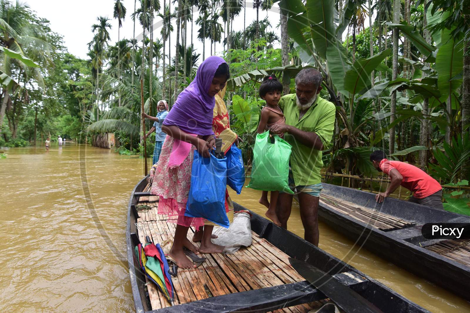 Flood Affected Villagers Arrive At A Safer Place On A Country Boat At  Bakulguri Village Near Kampur In Nagaon District Of Assam On May 27,2020.