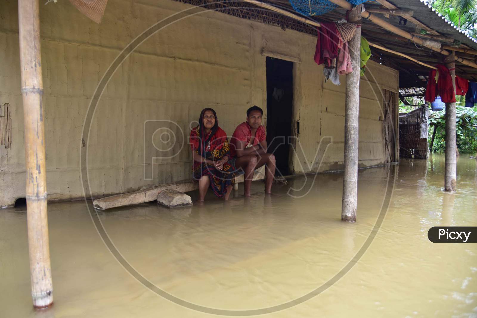 A Family sit  Inside their Submerged House At Flood Affected Bakulguri Village Near Kampur In Nagaon District Of Assam On May 27,2020.