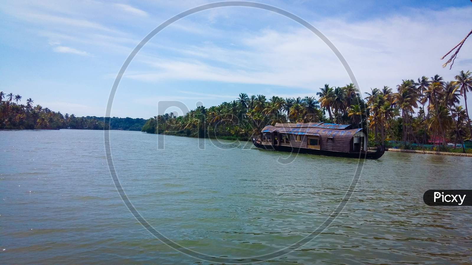A Houseboat Sailing In Ashtamudi Lake In Kerala. Kerala Backwaters.