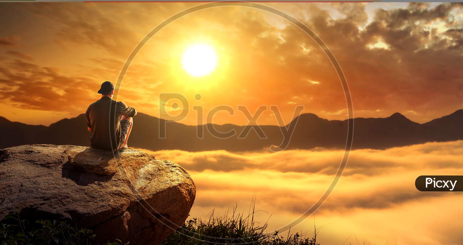 A Man Sitting On The Big Rock On A Cliff And Enjoying The Foggy Morning Sunrise In Mountains.