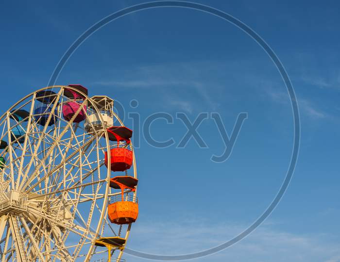 Colourful ferries wheel in the amusement park Tibidabo on background of blue sky, Barcelona, ​​Spain