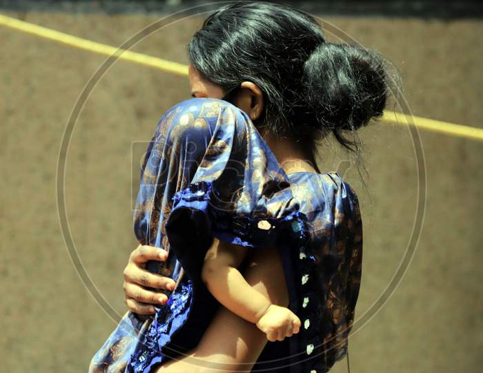 A Woman Covers Her Child On A Hot Day During extended Nationwide Lockdown amidst  Coronavirus or COVID-19 Pandemic  In Prayagraj, May 27, 2020.