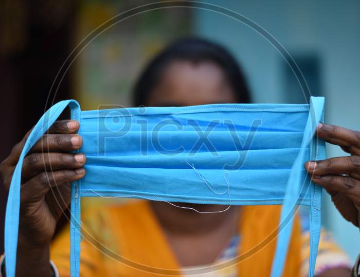 A woman SHG ( Self Help Groups) worker stitches face masks that are to be distributed among the poor in rural areas during an extended nationwide lockdown amid fears of coronavirus, May 7, 2020.