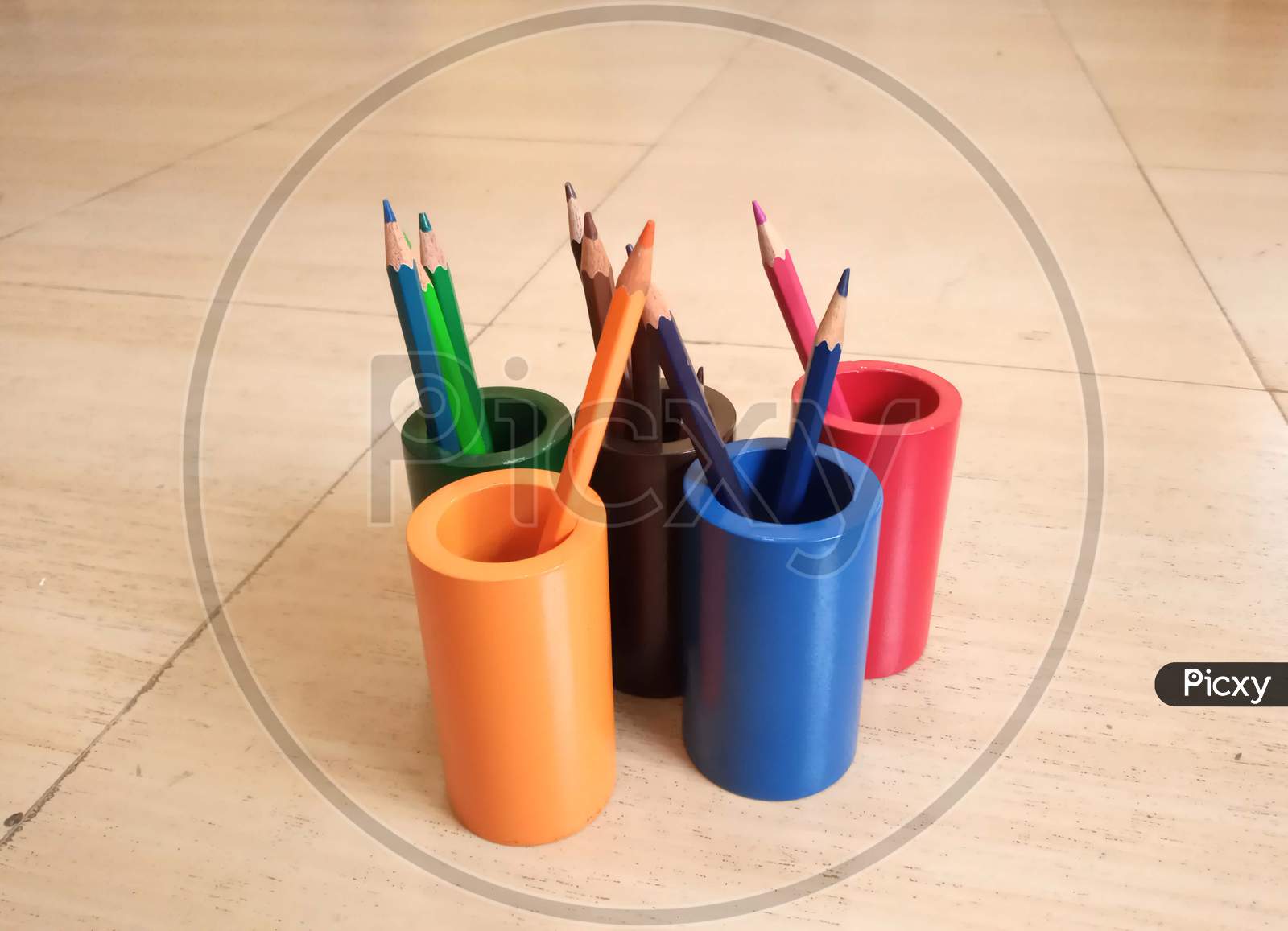 Colourful wooden stationery holder with colourful pencils in it.