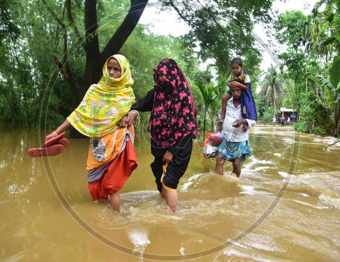 Villagers Wade Through A Flooded Area To Reach A Safer Place At  Bakulguri Village Near Kampur In Nagaon  On May 27,2020.