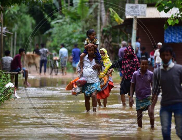 A Man Carries His Daughter As He  Wades Through A Flooded Area To Reach A Safer Place At Flood Affected  At  Bakulguri Village Near Kampur In Nagaon District Of Assam On May 27,2020.