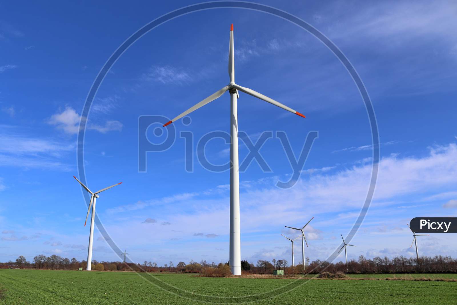 View on alternative energy windmills in a windpark in front of a blue sky