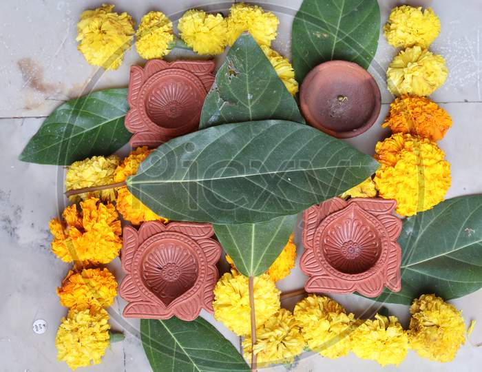 Swastika made using Marigold flowers for Ugadi with Clay Oil Lamp