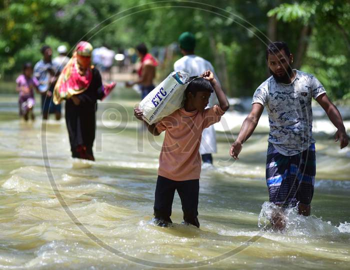 Villagers   Wade Through A Flooded Area To Reach A A Safer Place At Doboka  In  Hojai  District Of Assam  On May 28,2020.
