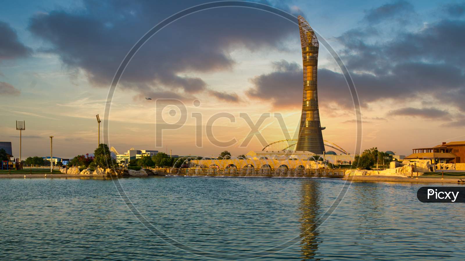 Doha,Qatar-December 7,2019: Aspire park daylight view with fountain and  The Torch Doha Hotel in background