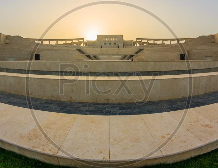 The amphitheater in Katara Cultural Village, Doha Qatar fish eye view in daylight with the sun in background