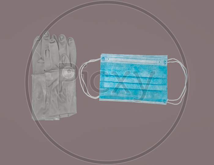 A Pair Of Rubber Medical Gloves, Surgical Mask Isolated On gray Background