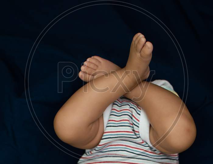 Legs On An Infant On Blue Background
