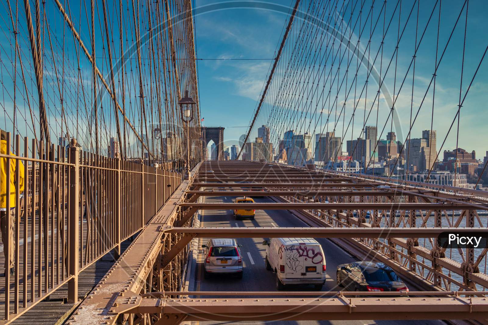 Brooklyn Bridge daylight view with cars moving on the bridge ,skyline and clouds in sky in background