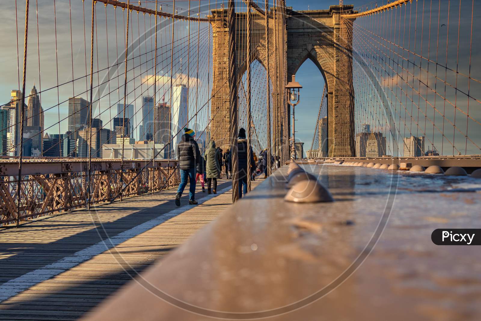Brooklyn Bridge daylight view with people walking on the bridge ,skyline and clouds in sky in background