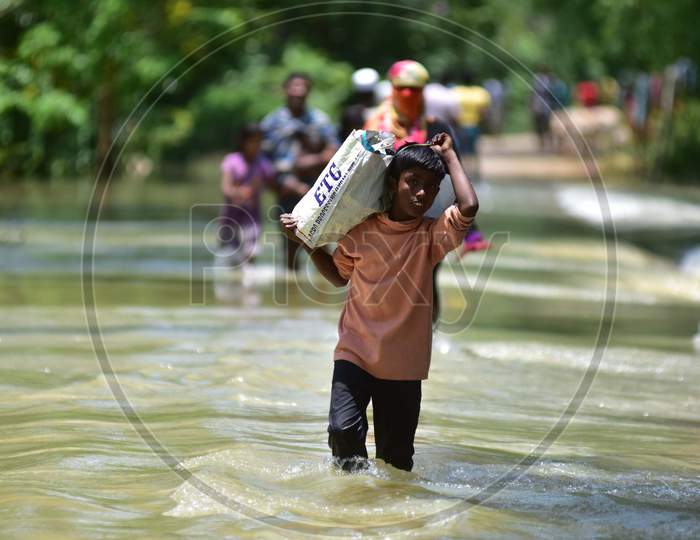 Villagers wade Through A Flooded Area To Reach a Safer Place At Doboka In Hojai District Of Assam On May 28,2020