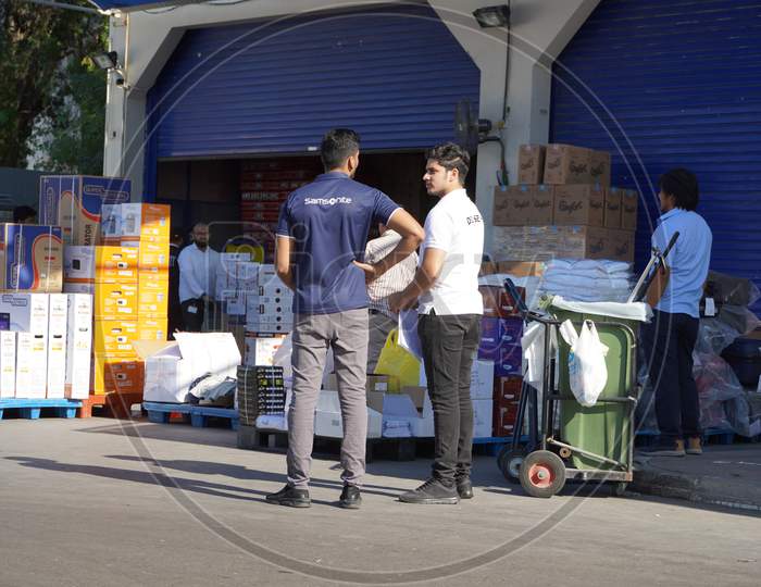 Workers With Manual Forklift And Boxes Stockpile Goods Near Storage Room In Wholesale Shop. Back Side Of Supermarket. Unloading Dock For Goods At Storehouse. Logistics Center.- Dubai Uae December 2019
