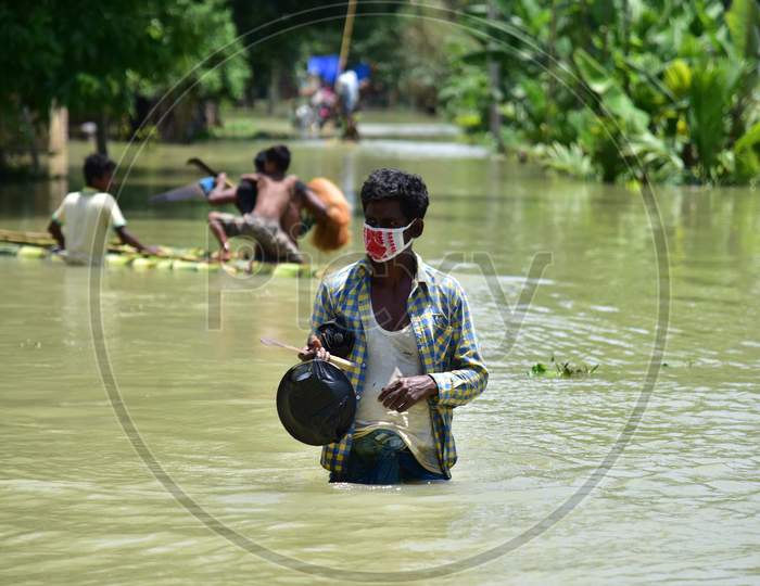 A Man Wearing Mask As He   Wade Through A Flooded Area To Reach A  Safer Place At Doboka  In  Hojai  District Of Assam  On May 28,2020.