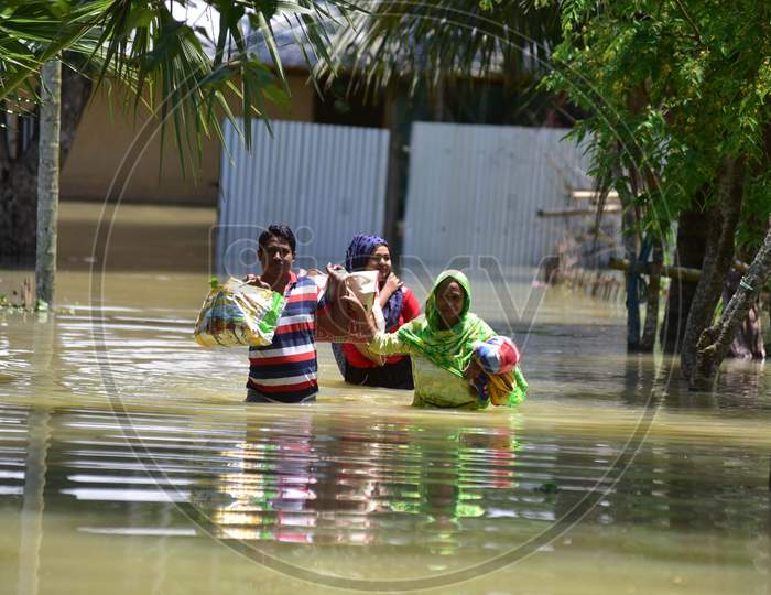 Villagers Wade Through A Flooded Area To Reach A Safer Place At Doboka  In  Hojai  District Of Assam  On May 28,2020.