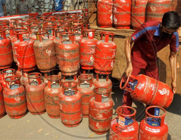 A worker unloads gas cylinders from a vehicle for people to purchase, after India ordered a 21- day nationwide lockdown to limit the spreading of coronavirus disease (COVID-19) in Mumbai, India on March 27, 2020.