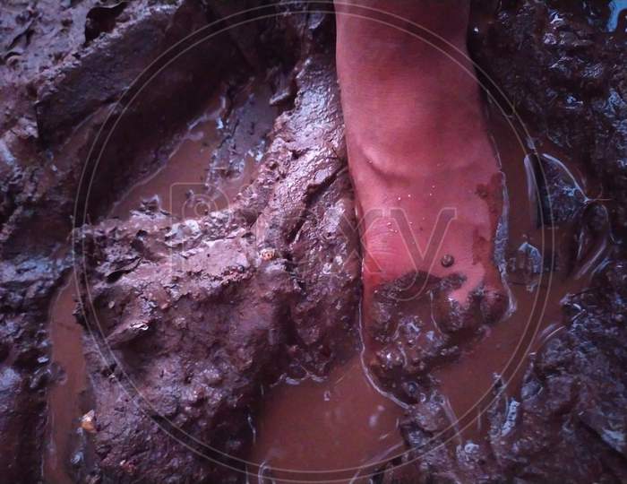 Single bare feet in muddy earth with footprint