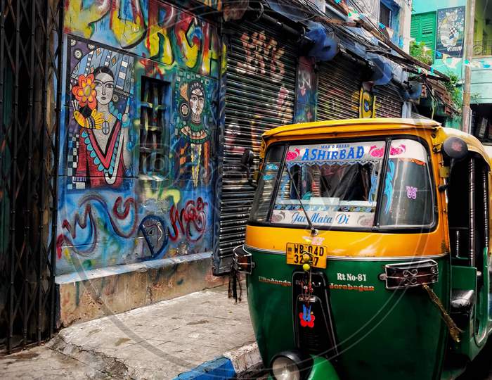 Parked auto rikshaw near to a graffiti wall