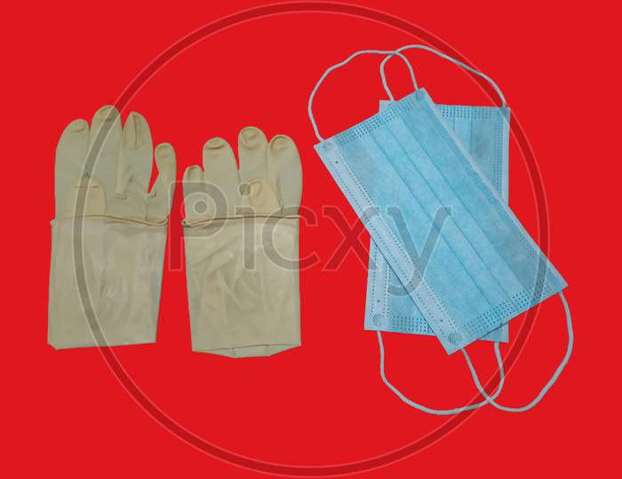 A Pair Of Rubber Medical Gloves And Surgical Mask Isolated On Red Background