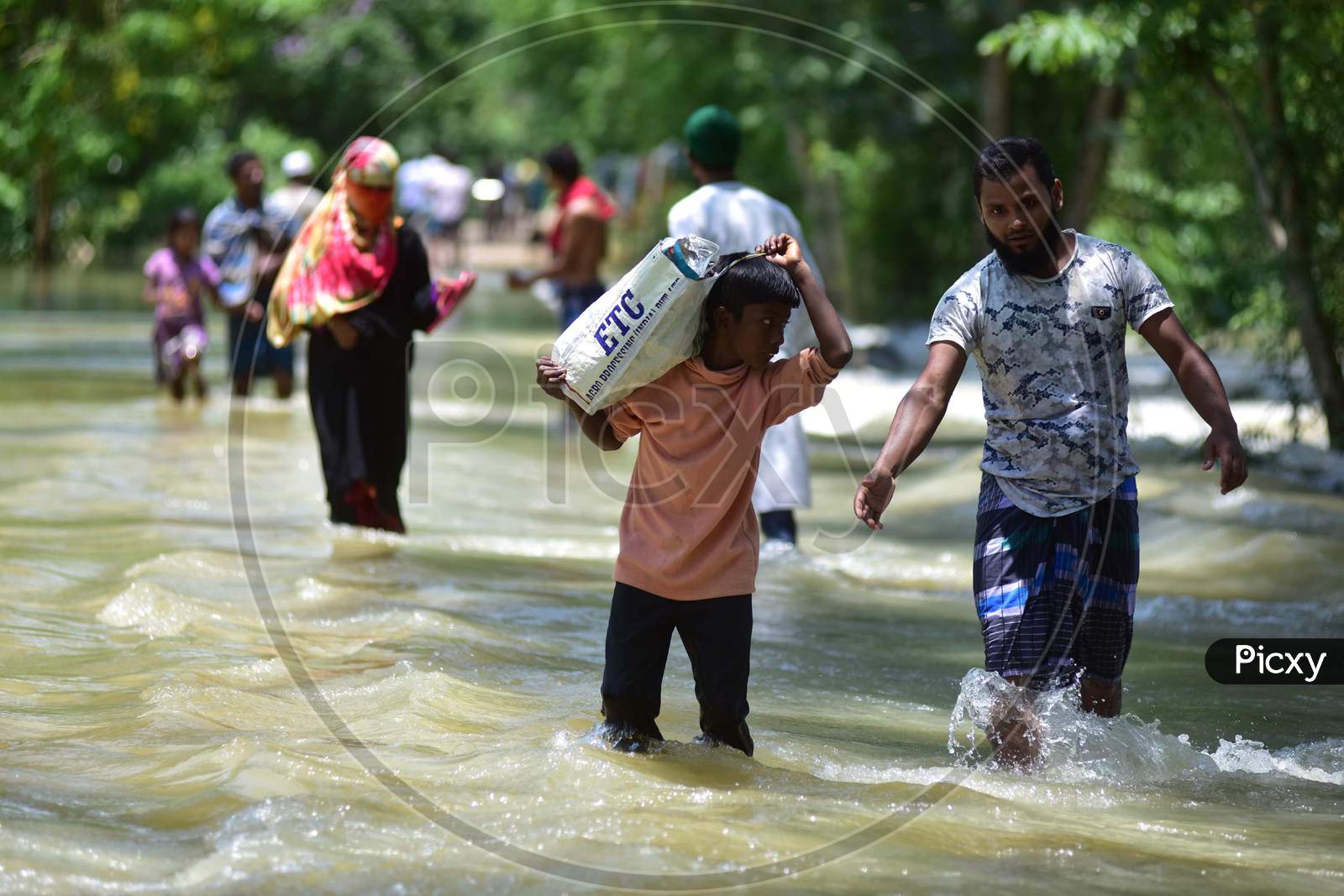 Villagers   Wade Through A Flooded Area To Reach A A Safer Place At Doboka  In  Hojai  District Of Assam  On May 28,2020.