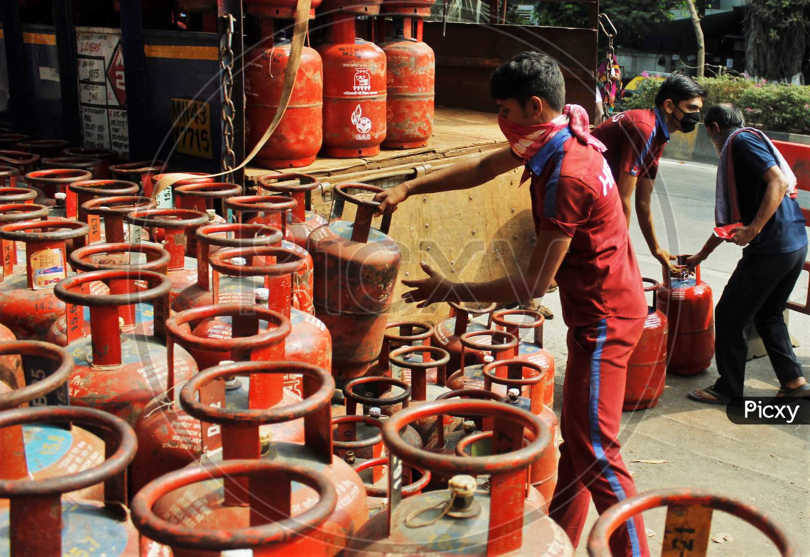 A worker unloads LPG gas cylinders from a vehicle for the people to purchase, after India ordered a 21- day nationwide lockdown to limit the spreading of coronavirus disease (COVID-19) in Mumbai, India on March 27, 2020.