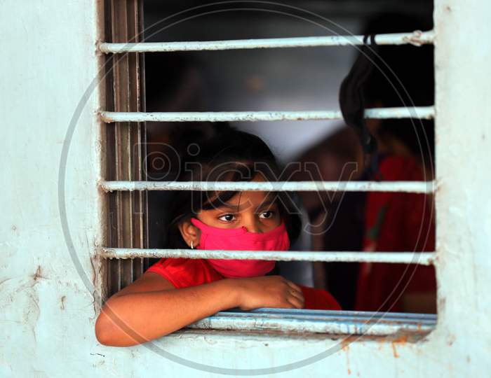 Migrant Girl peeps out of A Train Window as she travels In a Special Train  During Extended Nationwide Lockdown Amidst Coronavirus Or COVID-19 Pandemic in Prayagraj