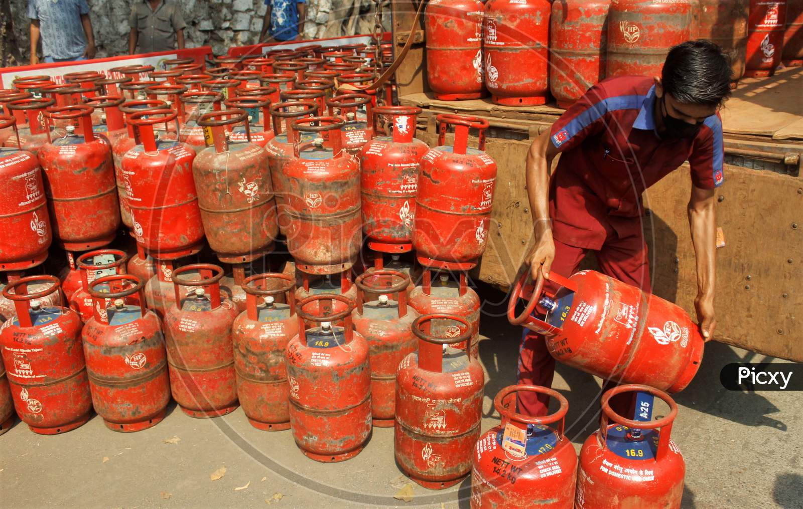 A worker unloads gas cylinders from a vehicle for people to purchase, after India ordered a 21- day nationwide lockdown to limit the spreading of coronavirus disease (COVID-19) in Mumbai, India on March 27, 2020.