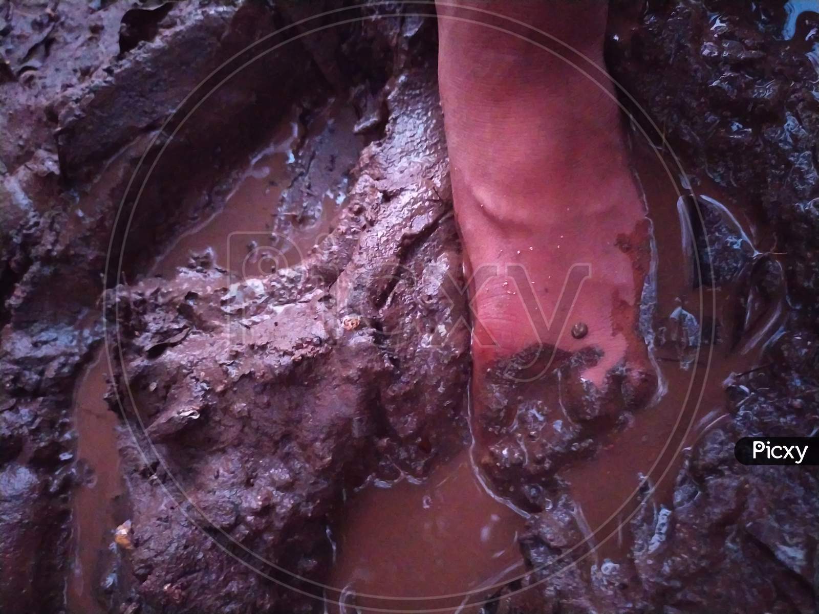 Single bare feet in muddy earth with footprint