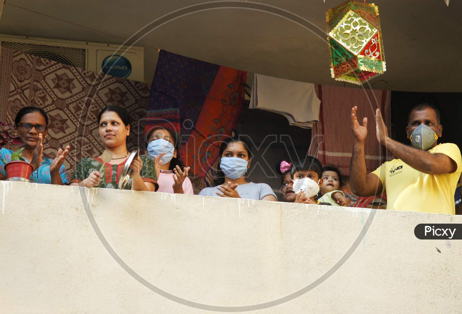 People clap and bang utensils from their balconies to cheer for emergency personnel and sanitation workers who are on the frontlines in the fight against coronavirus, in Mumbai, India on March 22, 2020.