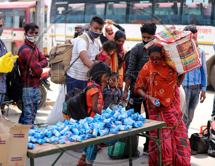 Migrants Taking Biscuit Packets Before Boarding Buses During Extended Nationwide Lockdown Amidst Coronavirus Or COVID-19 Pandemic in Prayagraj