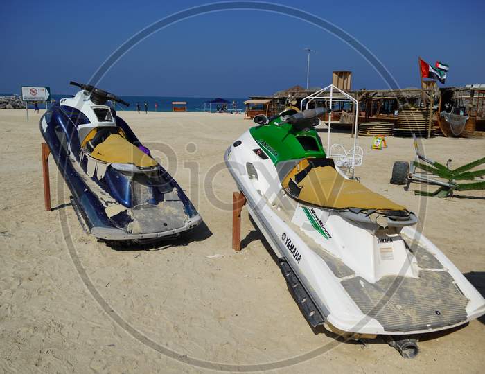Dirty Old Jet Ski Parked On The Beach Of Holiday Season. Old Jet Skis On The Beach On Wooden Trailer. Blue And White Jet Ski - Dubai Uae January 2020