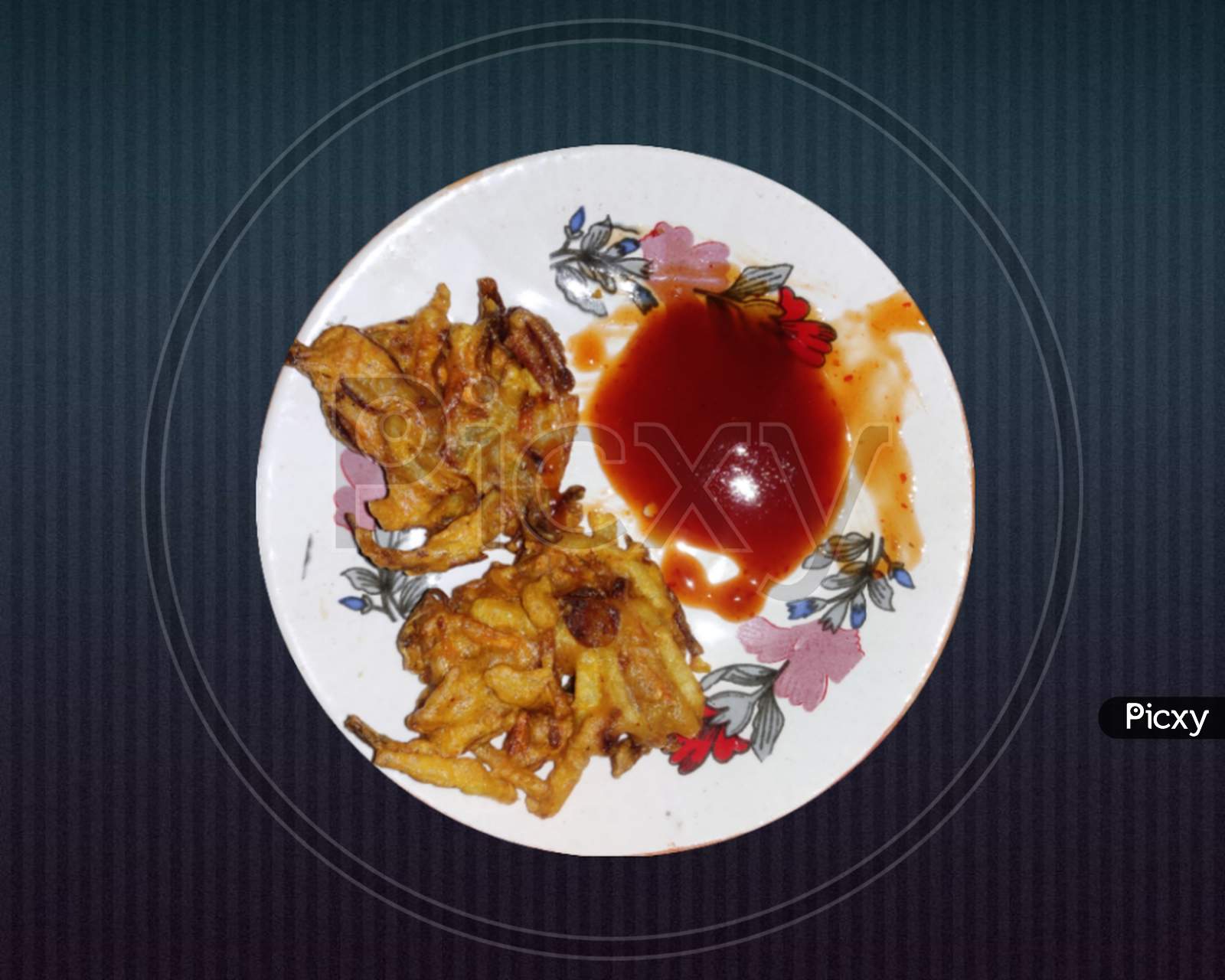Two pieces of Pakora or Piyaju and Tomato sauce in a white designed plate.