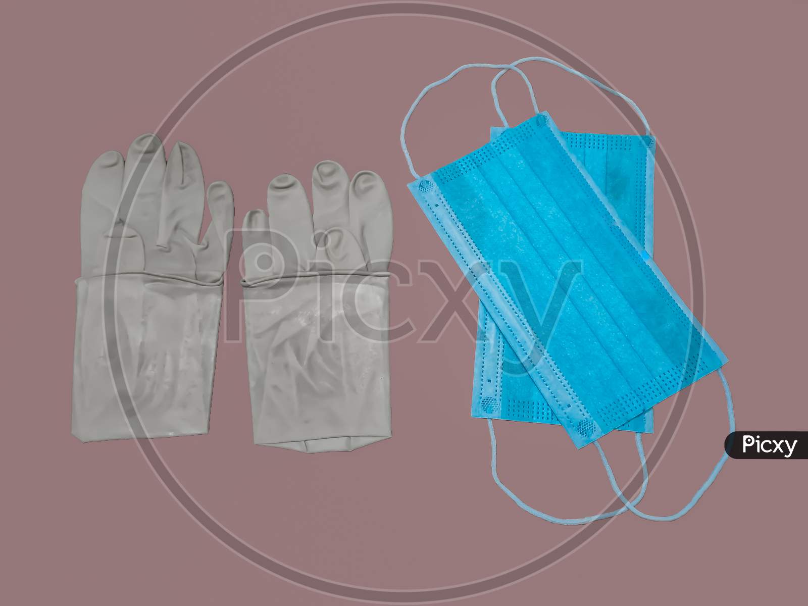 A Pair Of Rubber Medical Gloves And Surgical Mask Isolated On gray Background