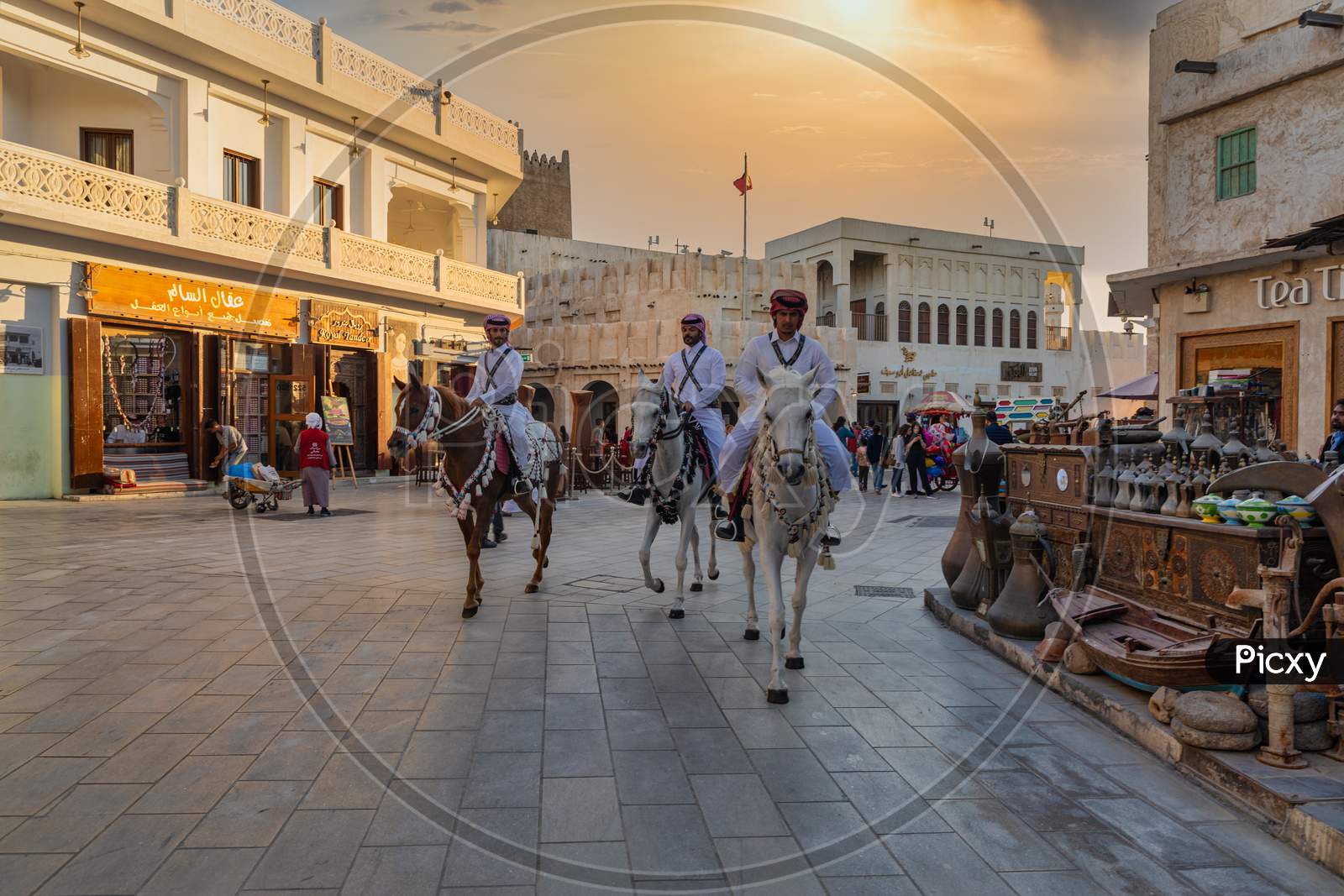 Souk Waqif Doha, Qatar main street daylight view  with traditional police riding horses and Qatari flag in background