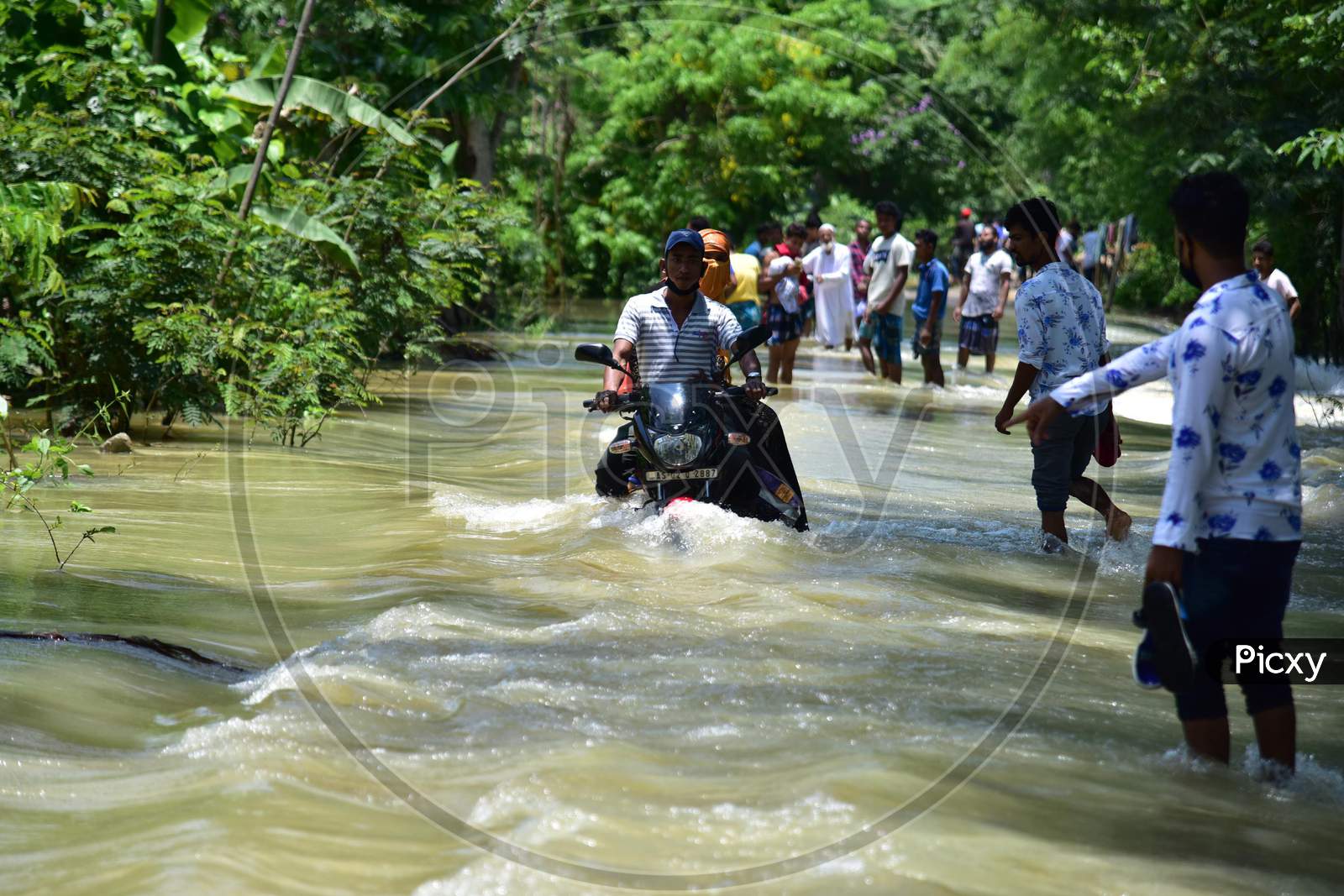 A Man Ride His Bike  Through A Flooded Area To Reach a Safer Place At Doboka  In  Hojai  District Of Assam  On May 28,2020