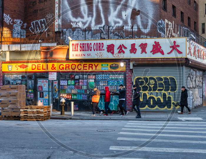 Chinatown neighborhood in Lower Manhattan NYC daylight view showing shops in the street with  Chinese letters ,symbols and people walking