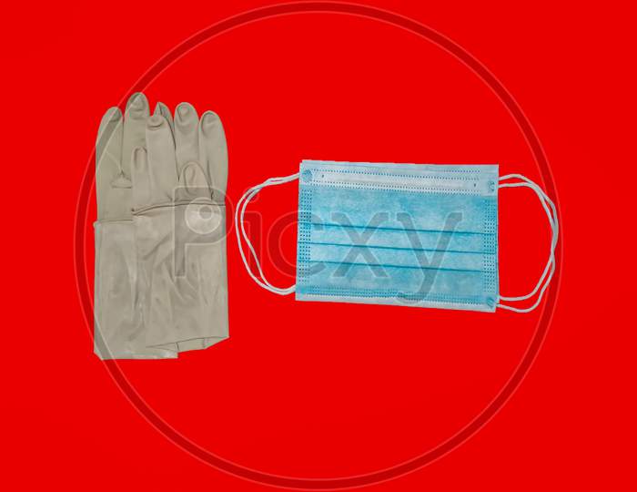 A Pair Of Rubber Medical Gloves, Surgical Mask Isolated On Red Background