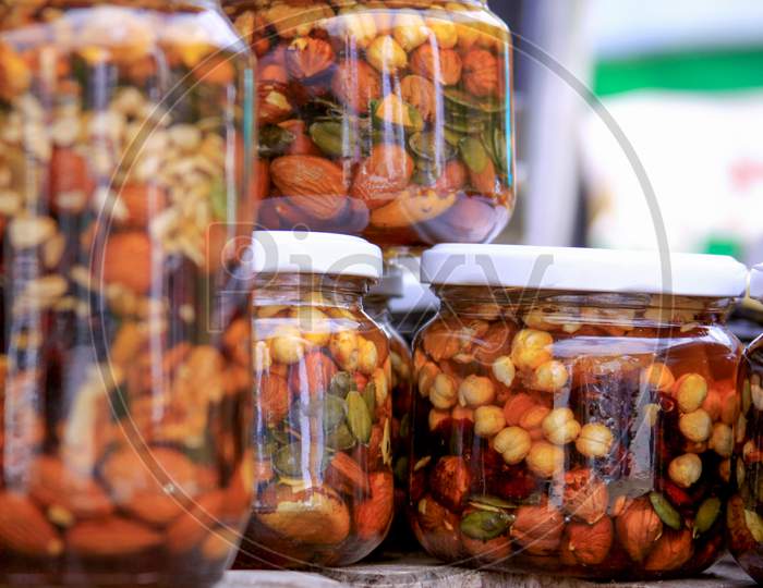 Various Types Of Nuts In Honey Jars