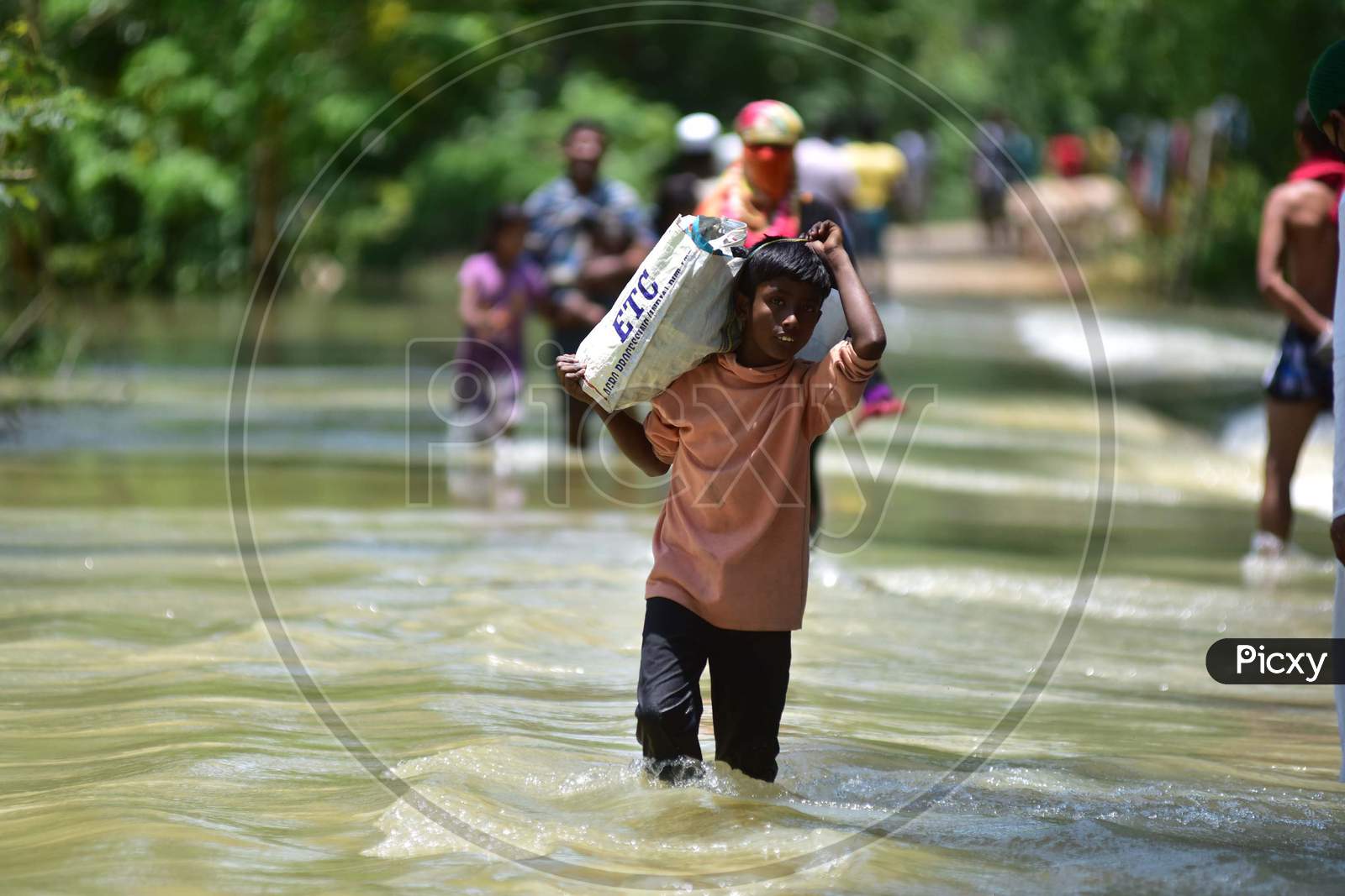 Villagers wade Through A Flooded Area To Reach a Safer Place At Doboka In Hojai District Of Assam On May 28,2020