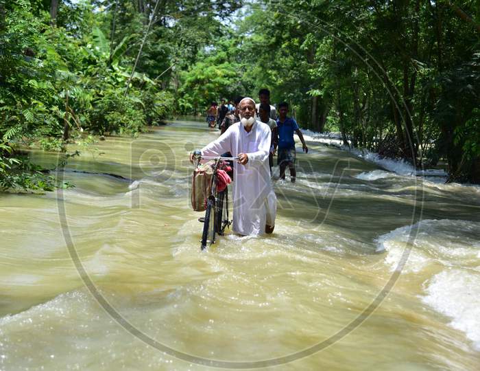 A Man Pushes His Bicycle Through A Flood Water At Doboka  In  Hojai  District Of Assam  On May 28,2020.