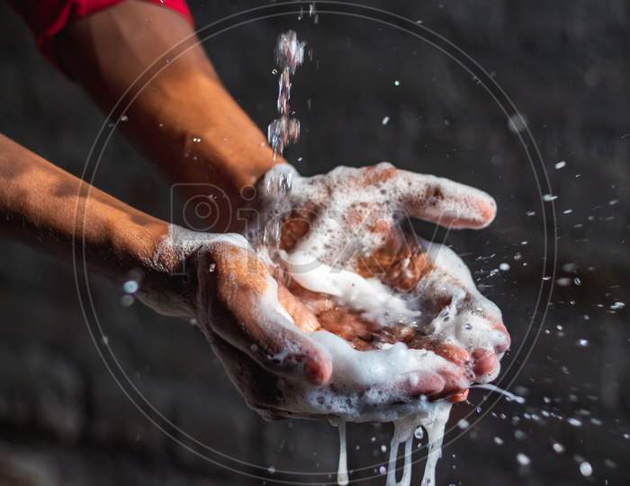 Washing Hands.Man Washing His Hands In The Garden At Home. Corona Virus Pandemic Prevention Wash Hands With Soap Warm Water And Rubbing Nails And Fingers Washing Frequently. Hygiene & Cleaning Hands.