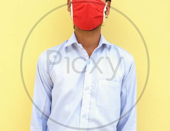 Photo of a young guy with two piece suit, wearing face mask for prevent from coronavirus during lockdown